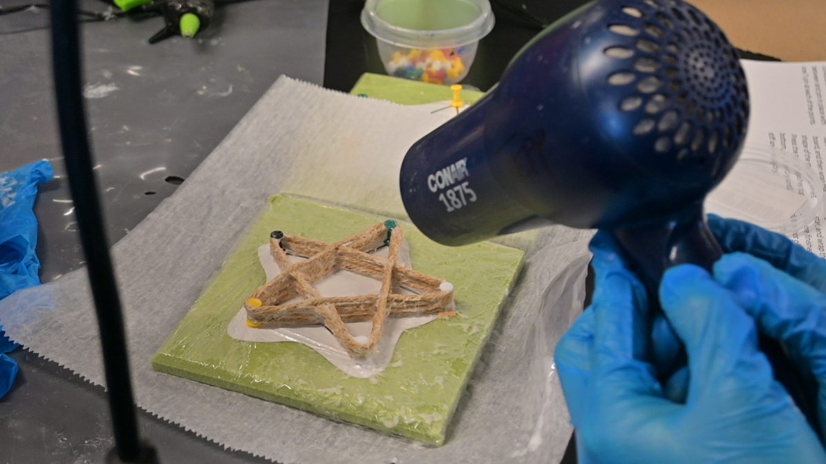 IN PROGRESS. Senior Nathan Rock dries a star using a hairdryer.