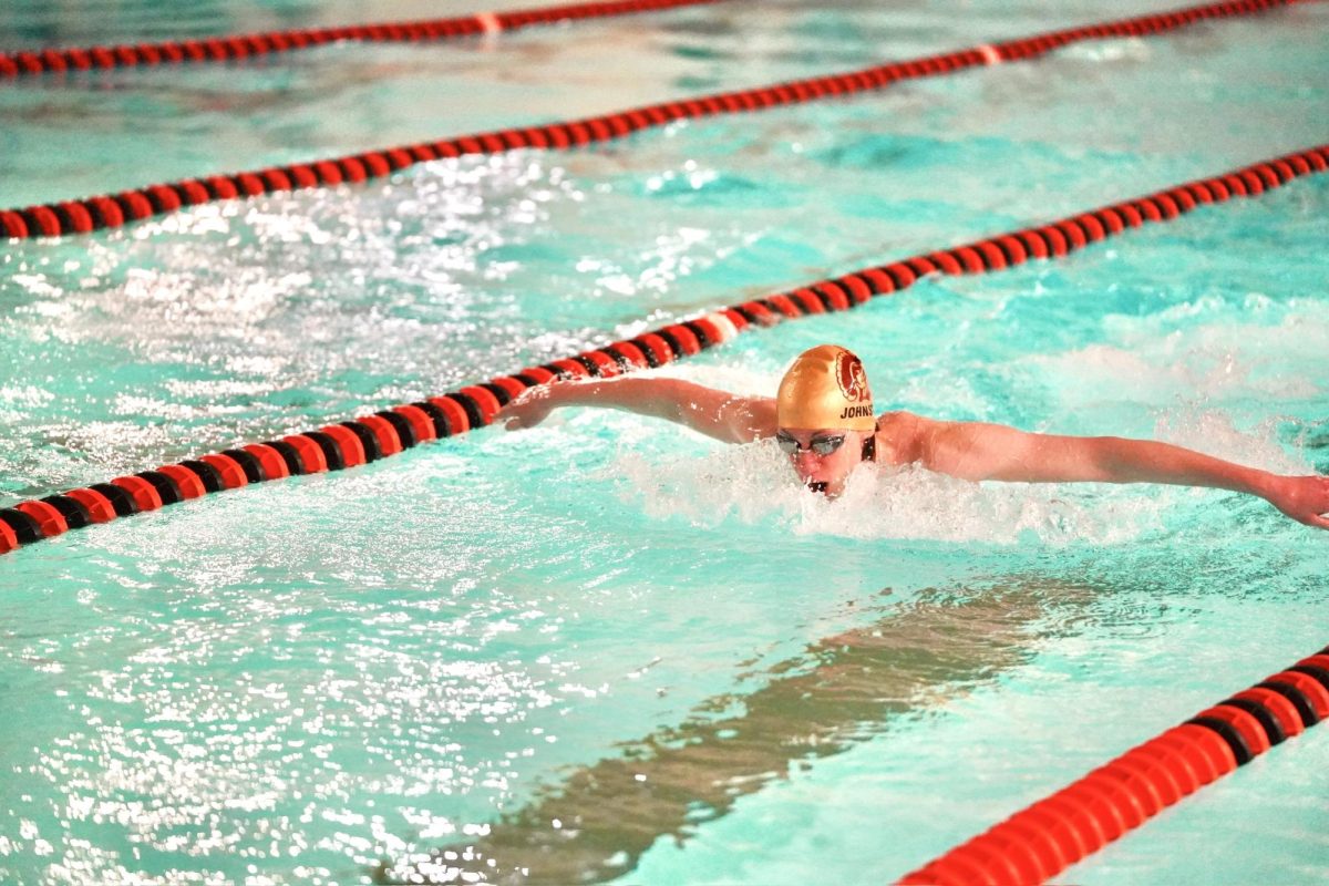 WINGS OUT. A swimmer from Highland stretches his arms in the butterfly event. 