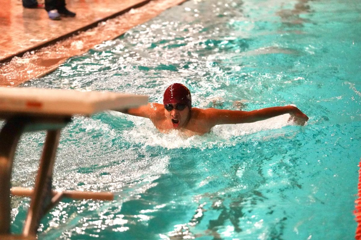 ONE MORE STROKE. Sophomore Adi Narayan nears the ending of the 100-yard butterfly. 