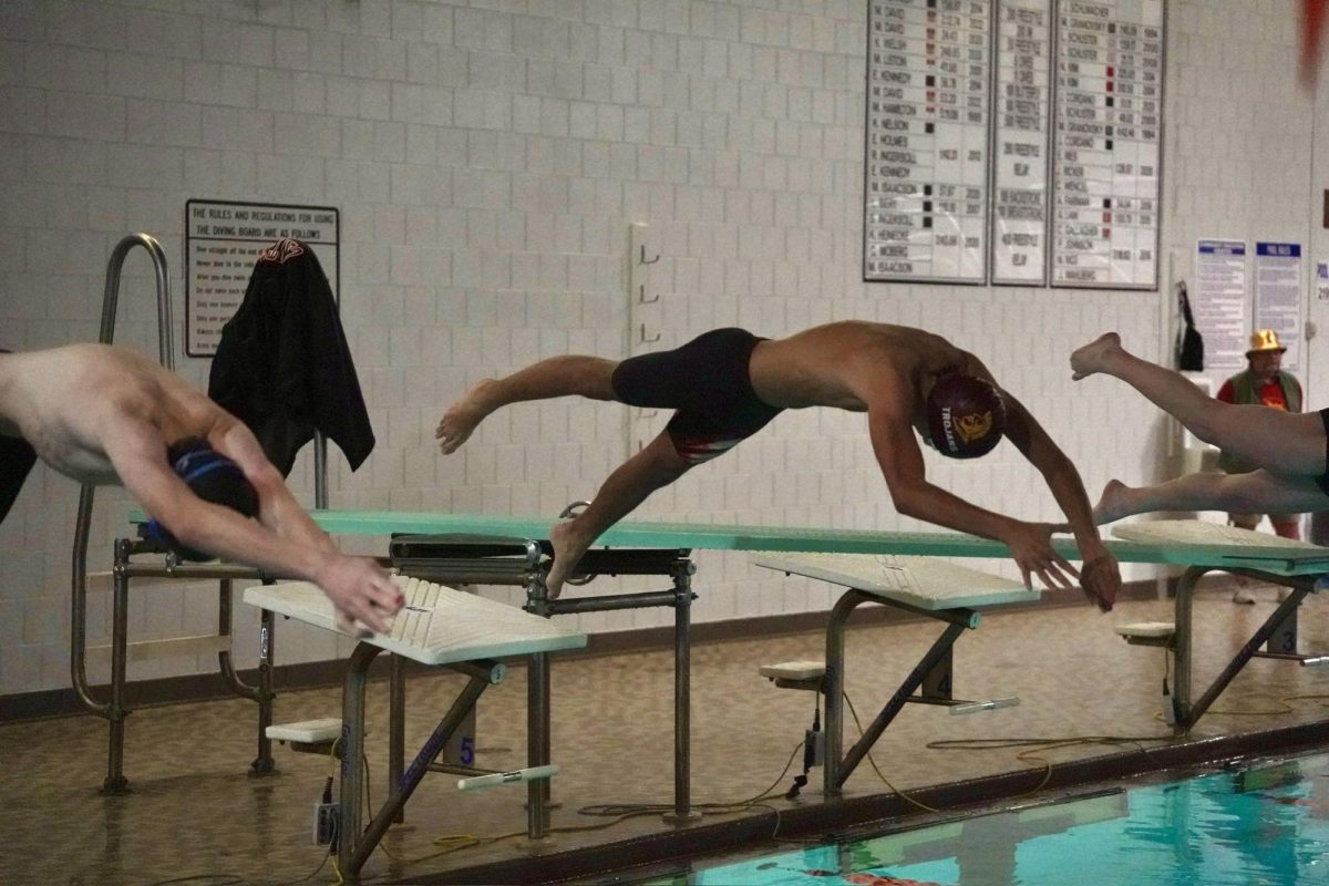 REACH. Sophomore Sam Galarneault dives off the block.