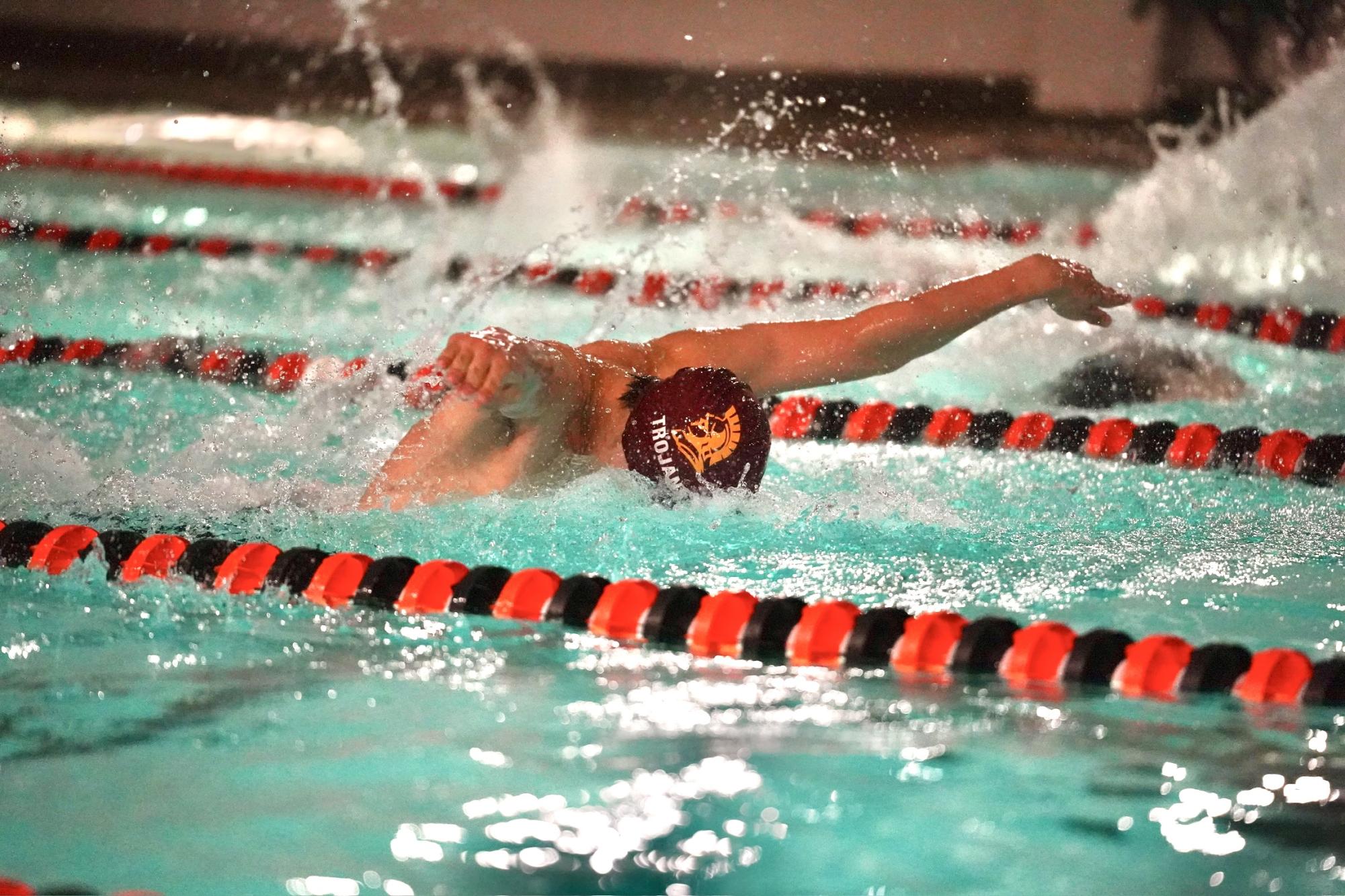 HEAD DOWN, ARMS OUT. Trojans swimmer competes in a fast 100-yard butterfly. 