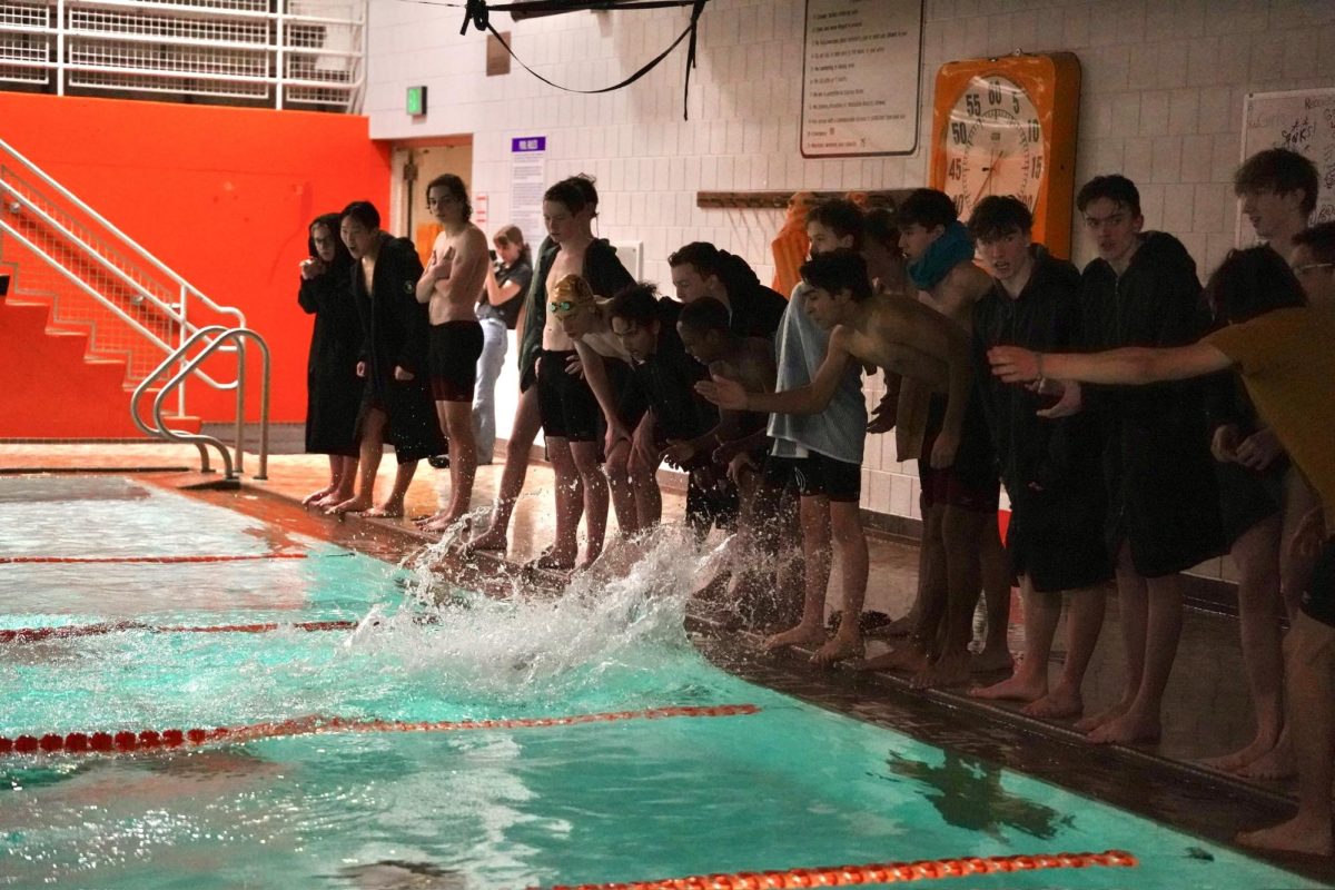 DOMINATING. Trojan swimmers cheer on their teammates in a fierce race.
