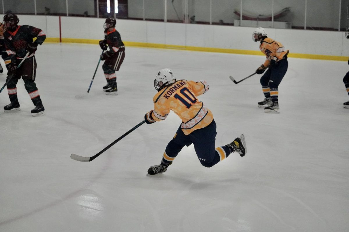 TAKE A SHOT. Senior Miles Kormann from Minnehaha takes a shot at the net through other players just past the blue line.