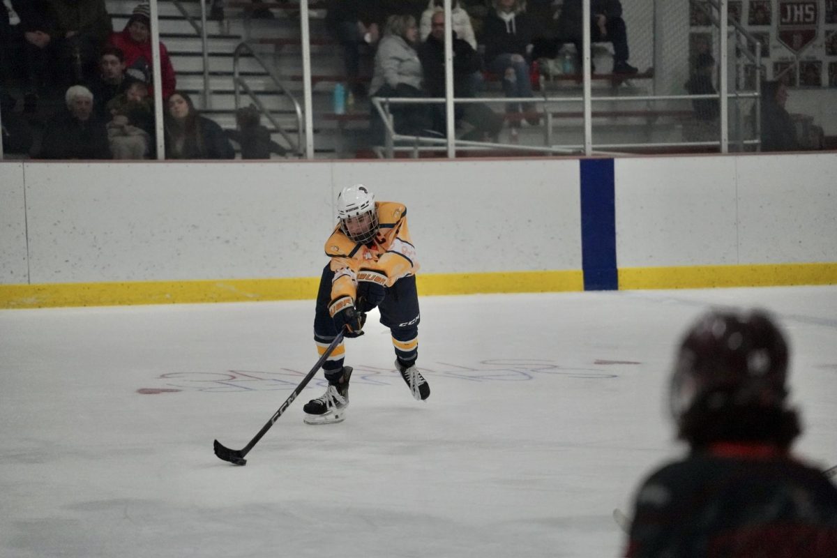 REACH. Senior Ethan Peltier reaches to catch the puck on his stick.