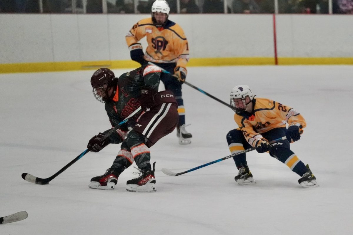 DEFENSE. Spartan players follow and keep their eyes on the puck as Johnson player tries to get around freshman Max George.