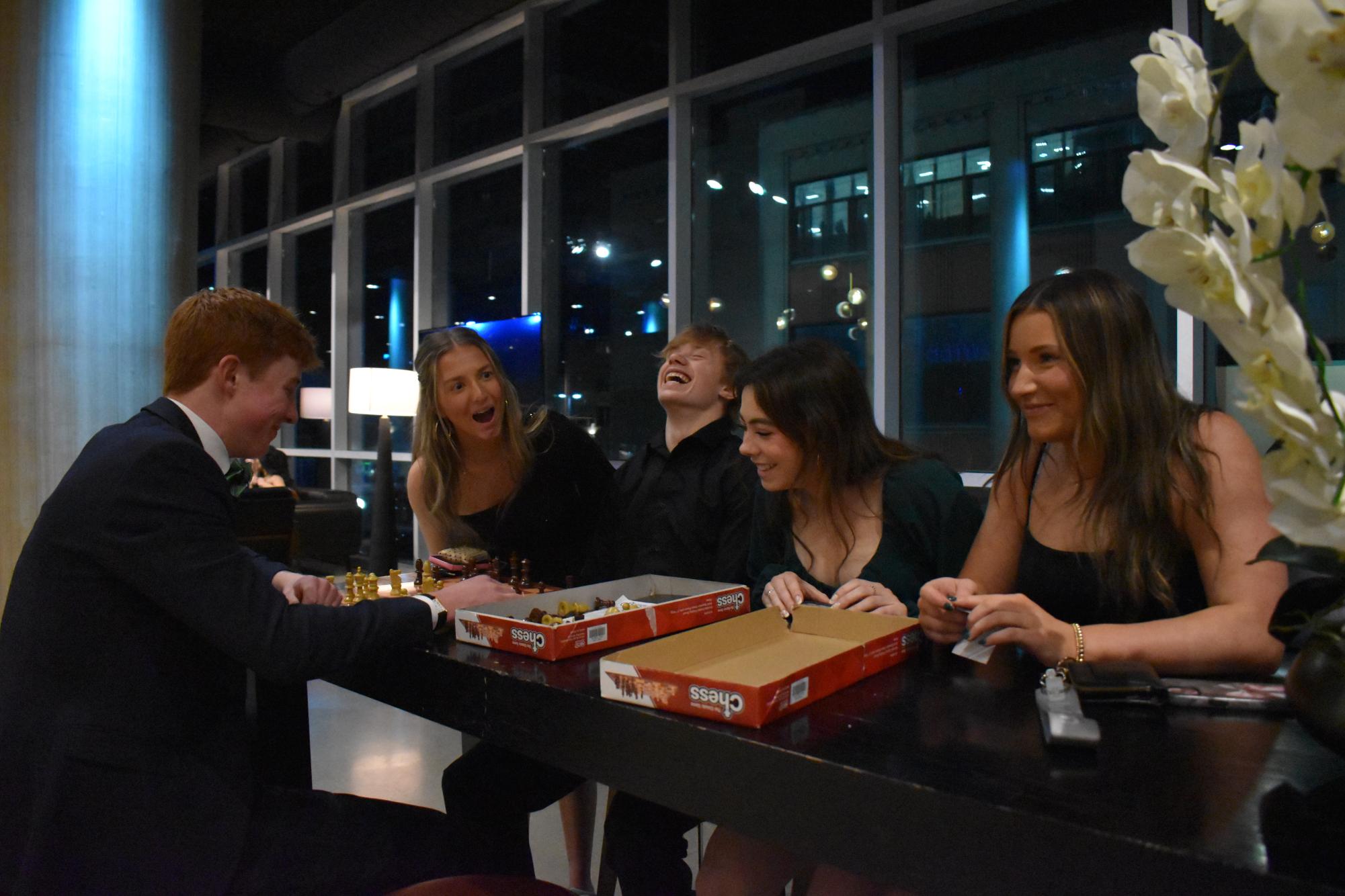 GAME TABLE. Sophomore William O'Brien cracks a joke to his friends while playing Chess and everyone laughs.