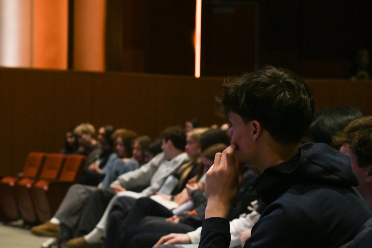 THOUGHTFUL LISTENING. Senior Nathan Rock sits in the front row of the auditorium and listens as the student panel share their experiences with volunteering. 