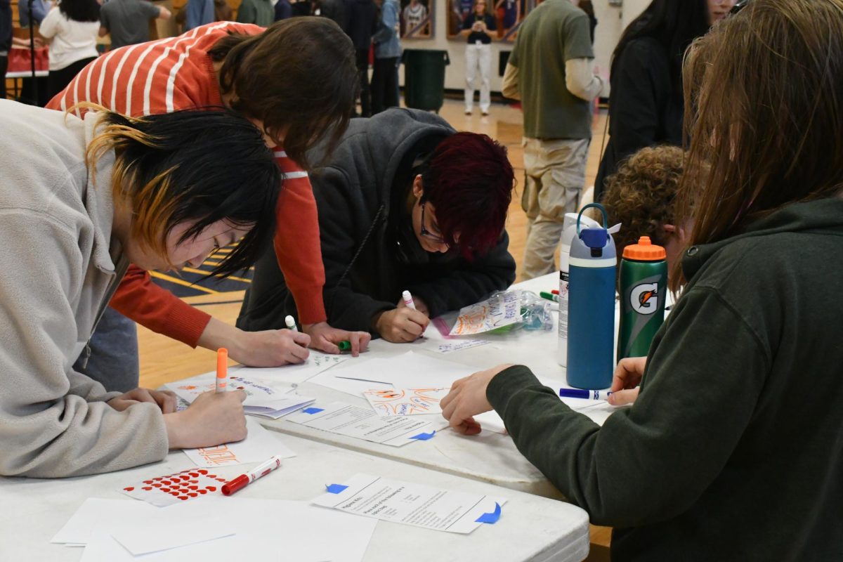 CLEAN AND COLORFUL. At the end of the table for packing hygiene kits, students draw on cards cute illustrations and write words of encouragement. The cards add a touch of color to the kits.