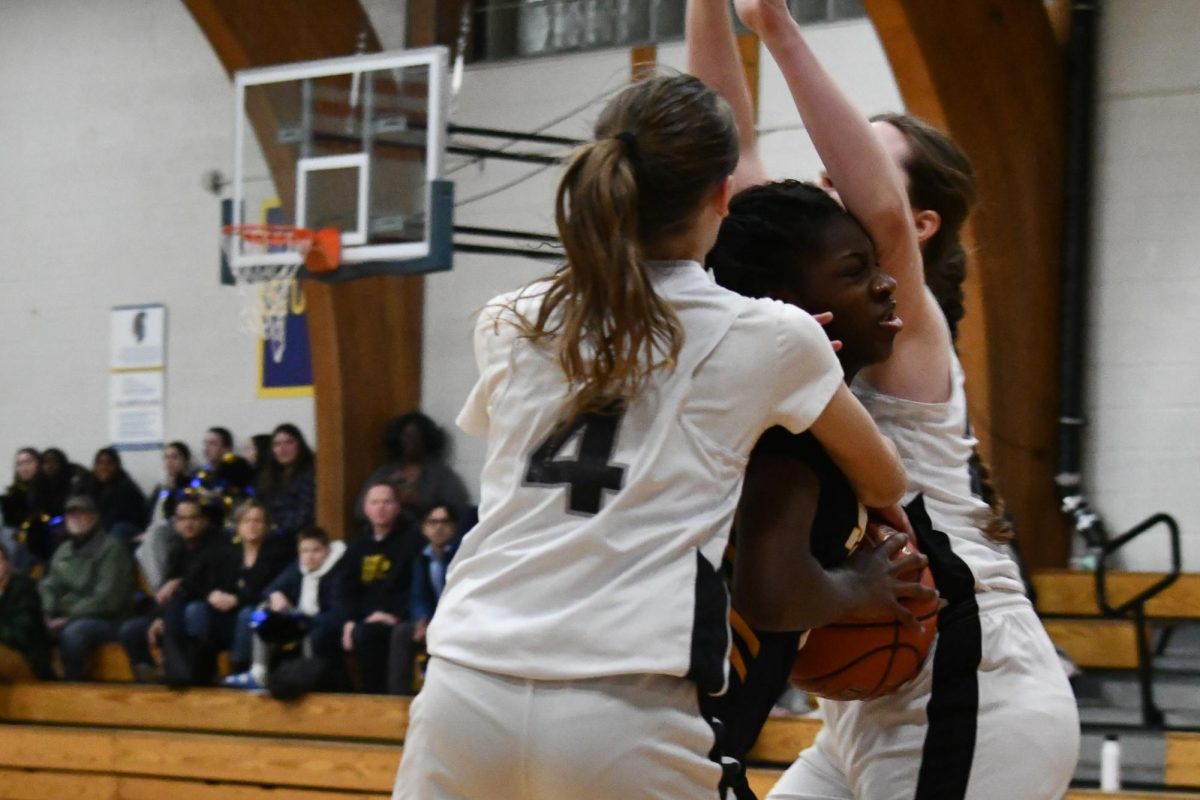 BREAK THROUGH. 7th grader Amaya Obi-Walker is blocked by two Avail Academy players and gets to take free throws due to the foul.