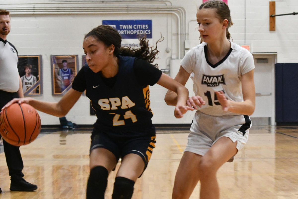 CHARGE FORWARD. Senior Julia Taylor  drives the ball forward towards the net as player 15 from Avail Academy defends with man-to-man defense. 