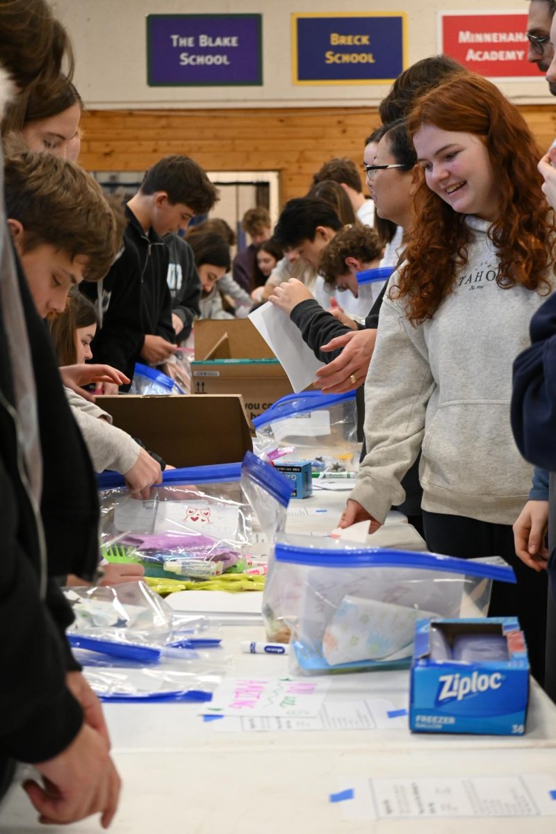 ASSEMBLY LINE. Students gathered around stations with their advisories to make hygiene kits for STAR House.