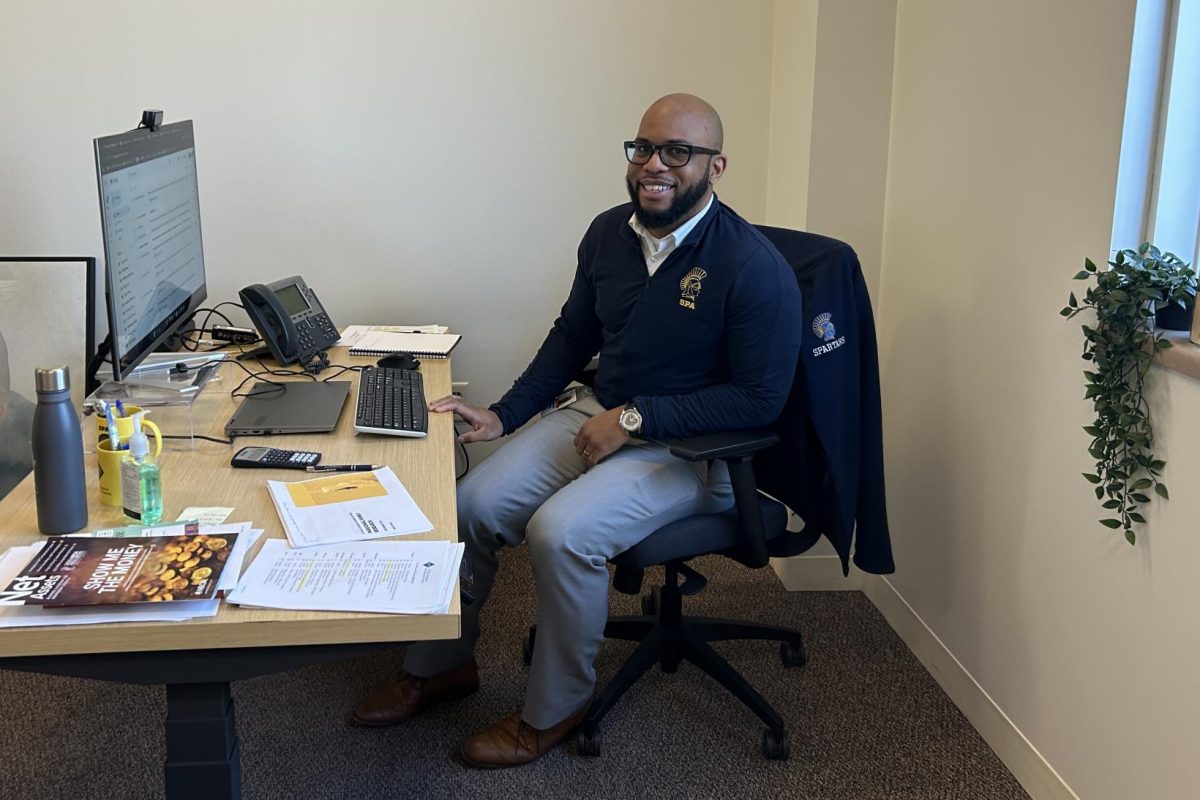 NEW TO SCHOOL. Sylvester Cutler, the Director of Enrollment Management, sits at his desk in the Admissions offices. Although he's new to the office he already knows a lot and our interview really showed how caring he is. He said, “Students that traditionally have fallen through the cracks of public school, find that when you come to a school like this, there's it's more nurturing environment.”