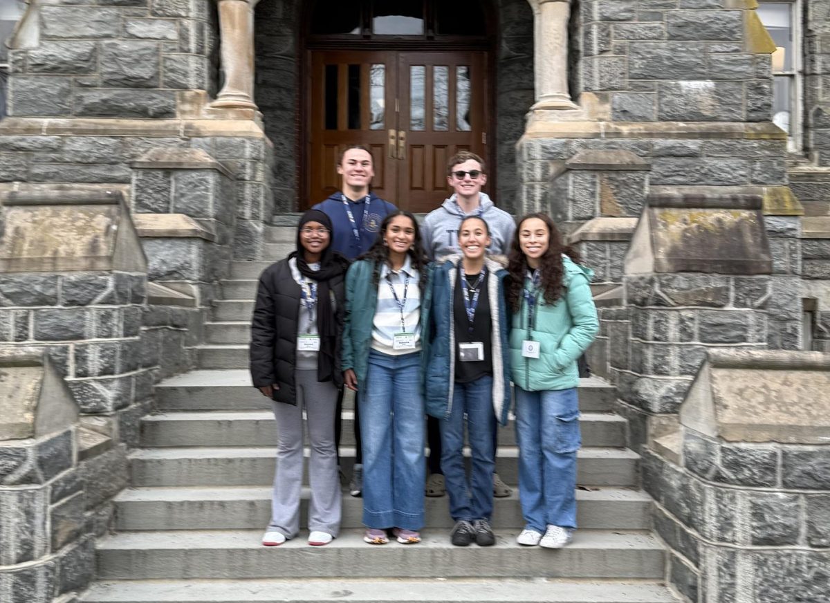 CAMPUS TOUR. (From top to bottom, left to right) Sophomore Langston Thompson, junior James Welsh, sophomore Anessa Herzi, sophomore Nabeeha Qadri, senior Raven Glaser and senior Julia Taylor stand on the steps of Healy Hall at Georgetown University.