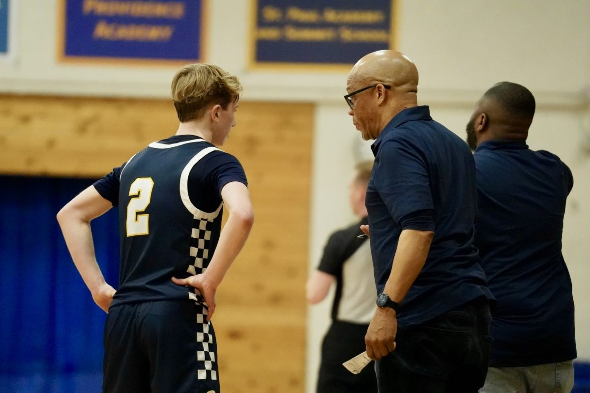 COACH TALK. Junior Ben Sieben talks with his coach to discuss the game.