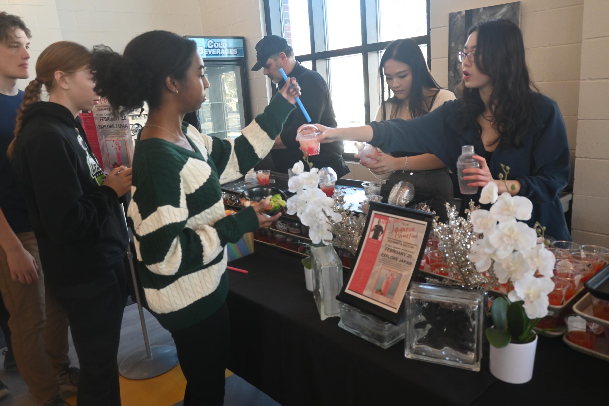 DISHING OUT. Senior Deling Chen hands Sophia Obi a boba tea drink she prepared.
