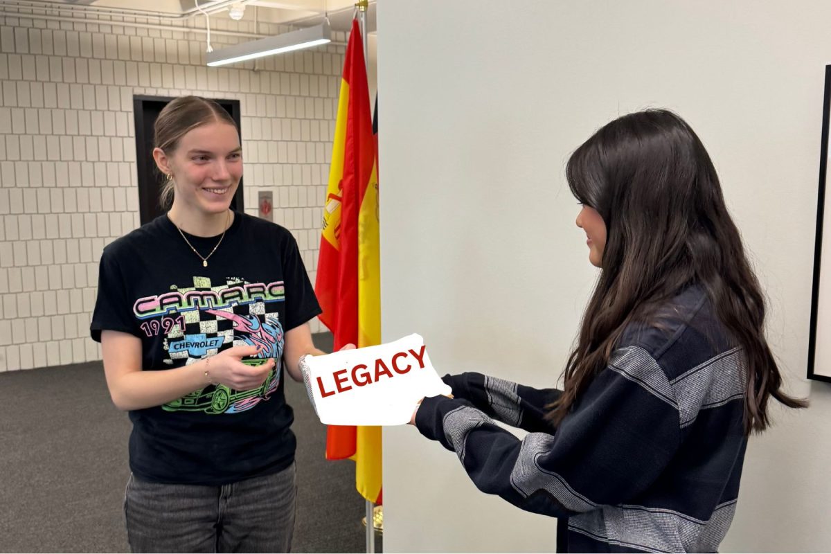 PASS IT ON. Senior Natalie Weibel passes on her legacy to a ninth-grader in SAC. 