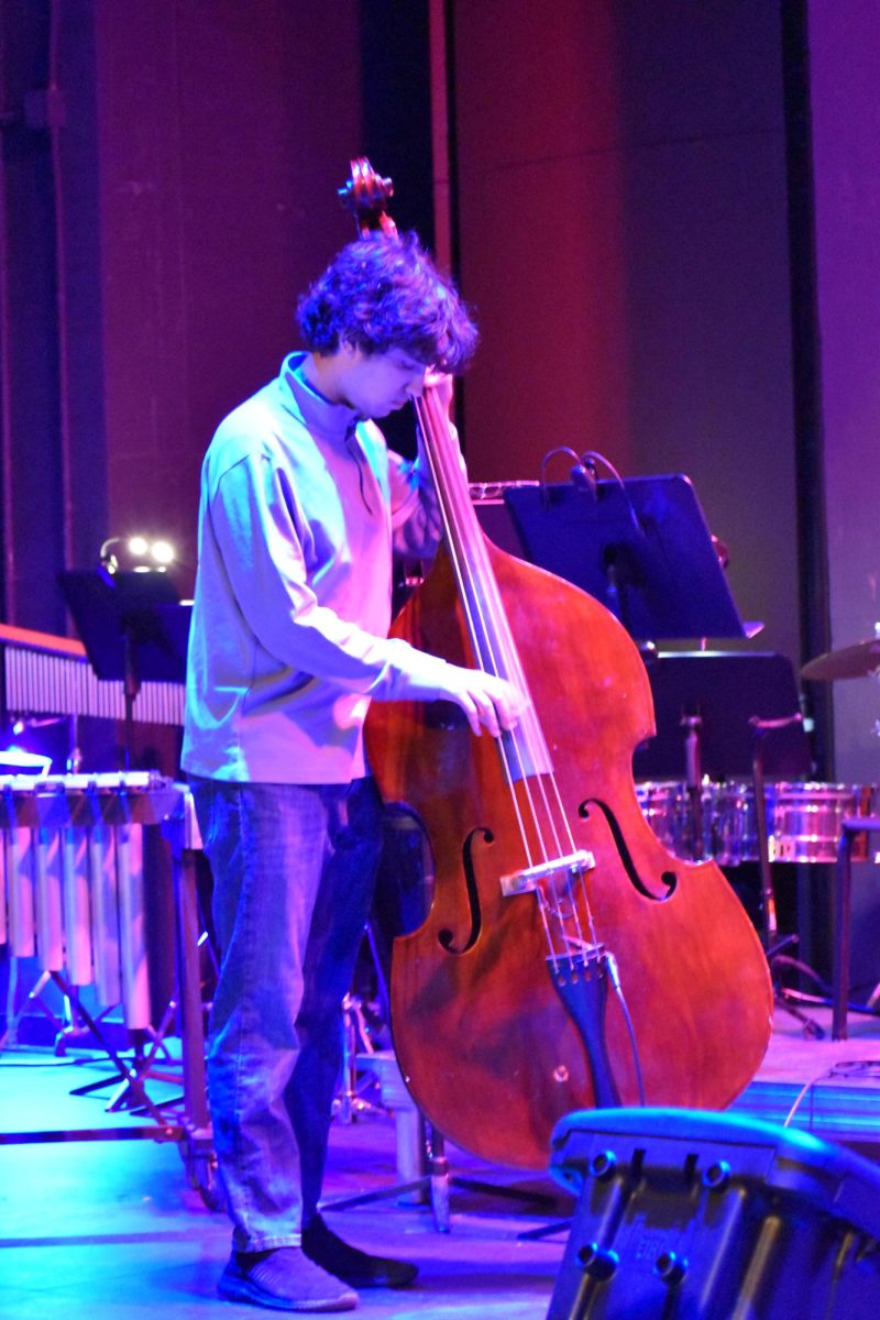 STRINGS. Junior Ryan Kari switches out his electric bass for a classical one for the third song of the Quintet's performance.