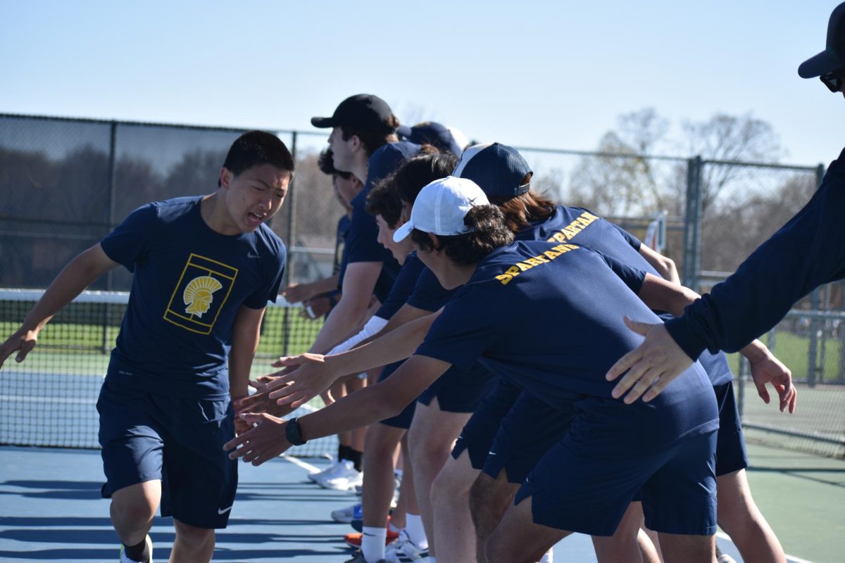 RUN THROUGH. Junior Allan Wang gets amped up as he high fives the whole team in the pre-game line up. 