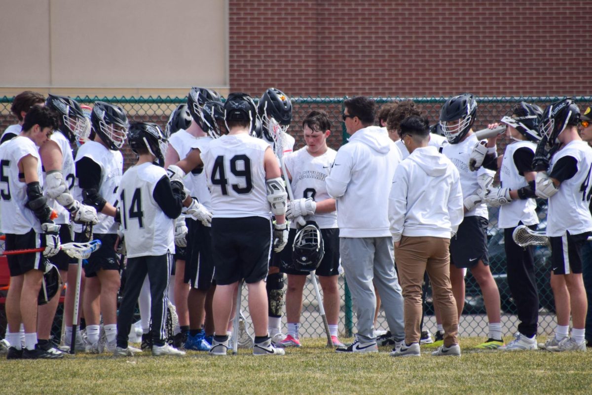 TEAM HUDDLE. The Blackhawks huddle up after the first quarter. Senior Dylan Bump listens intently to his coach and teammates.