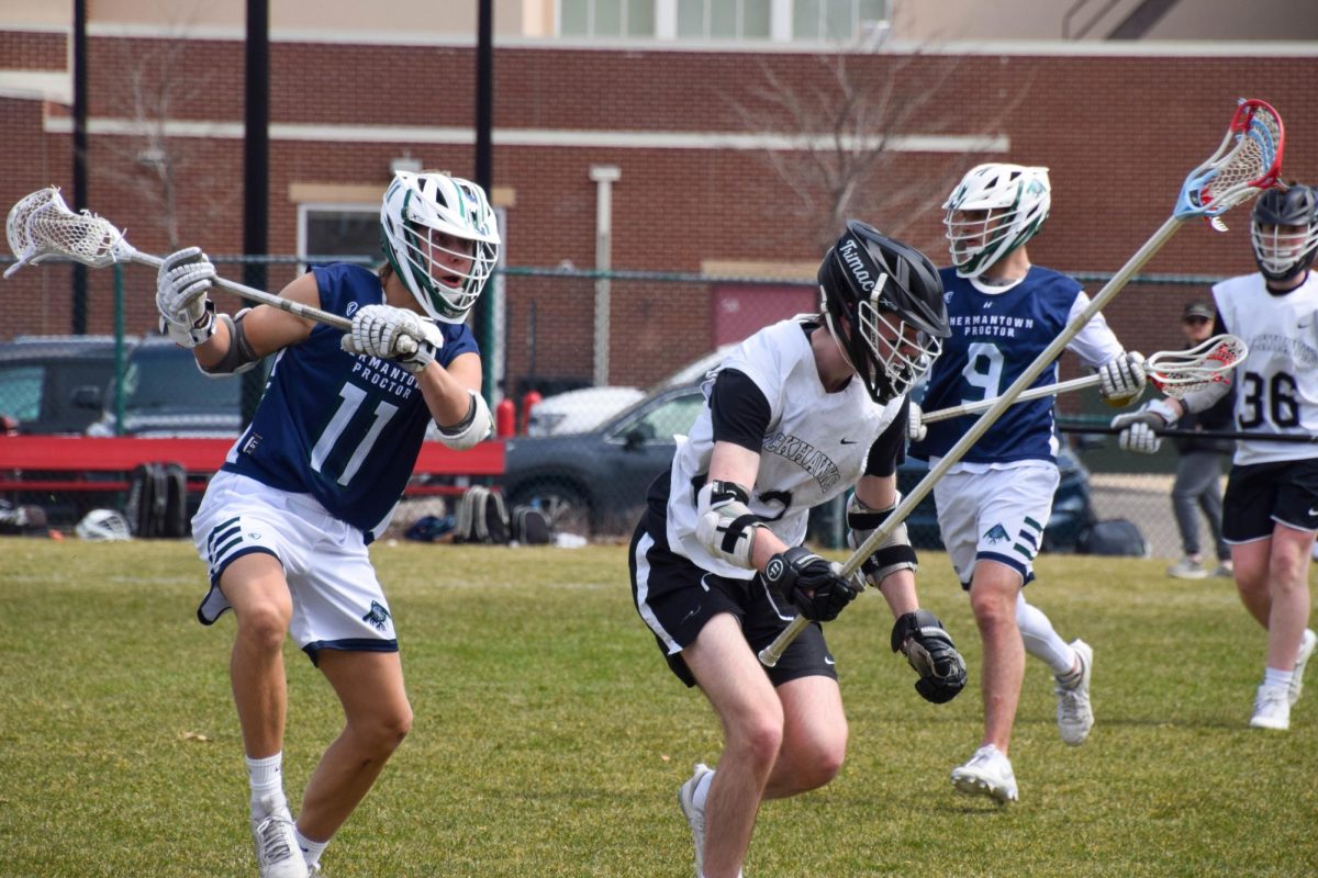 FULL FOCUS. A Blackhawks defender, characterized by the long stick, chases the ball with an attackman in full pursuit. 