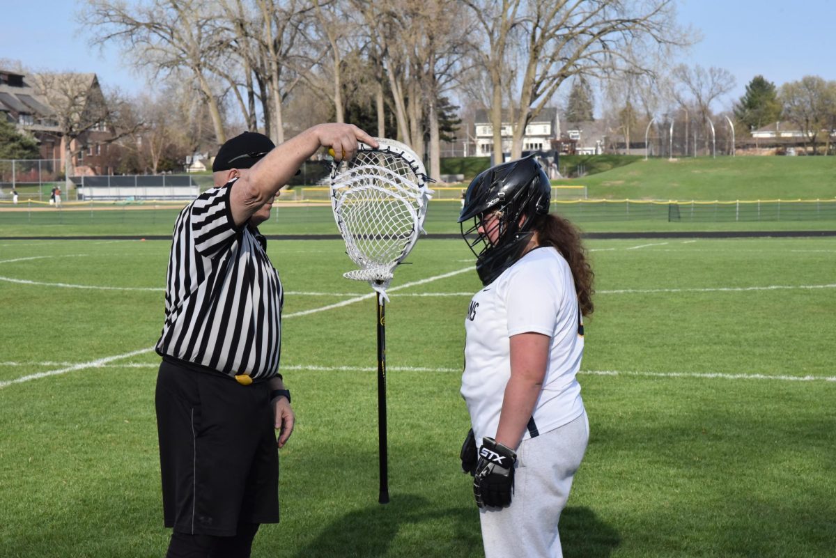 CHECK IN. 8th grader Avery Dayton gets her goalie stick checked before starting the game. 