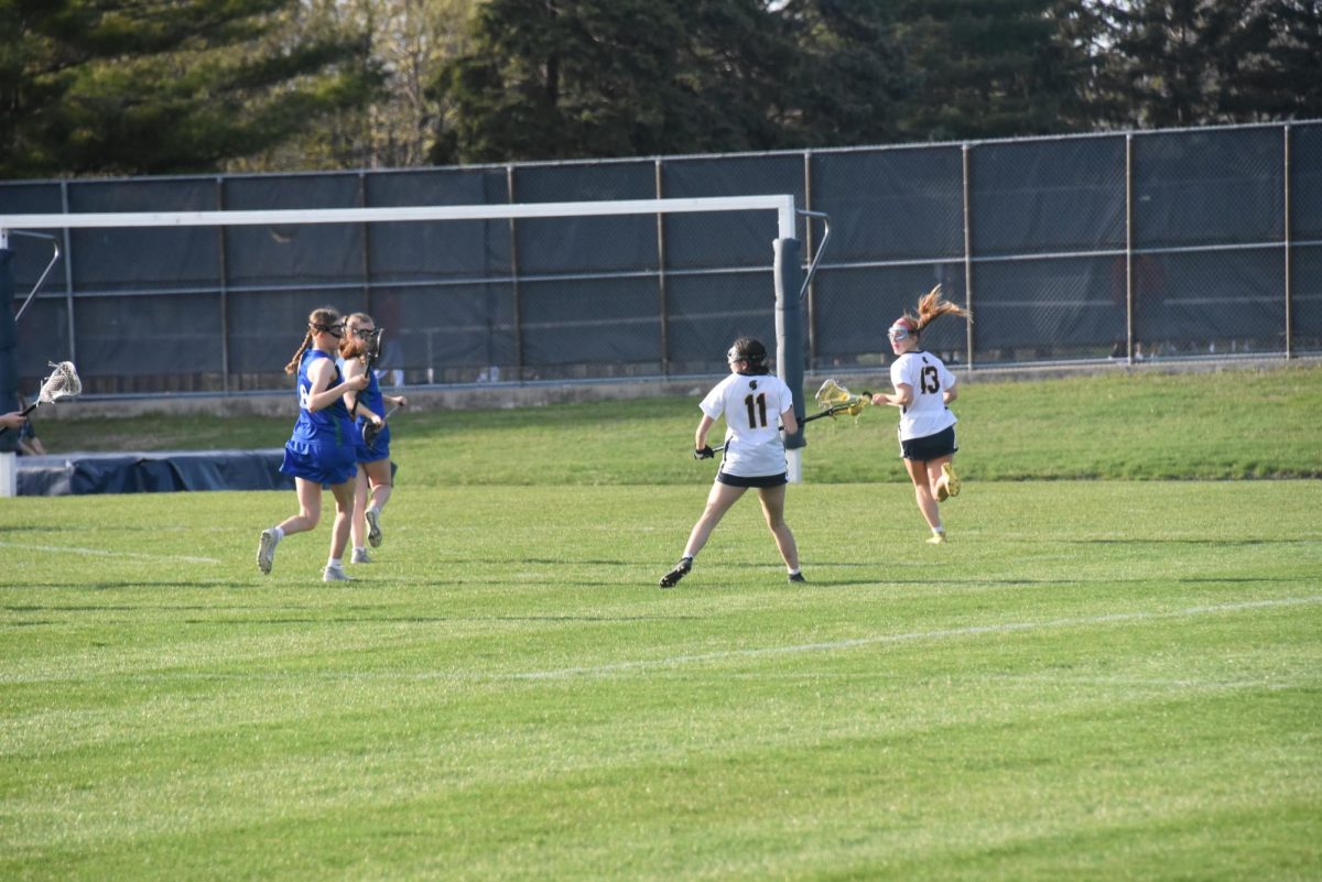 OVERLAP. Junior Dia Chaney cradles the ball as Senior Mia Collins runs around her. 