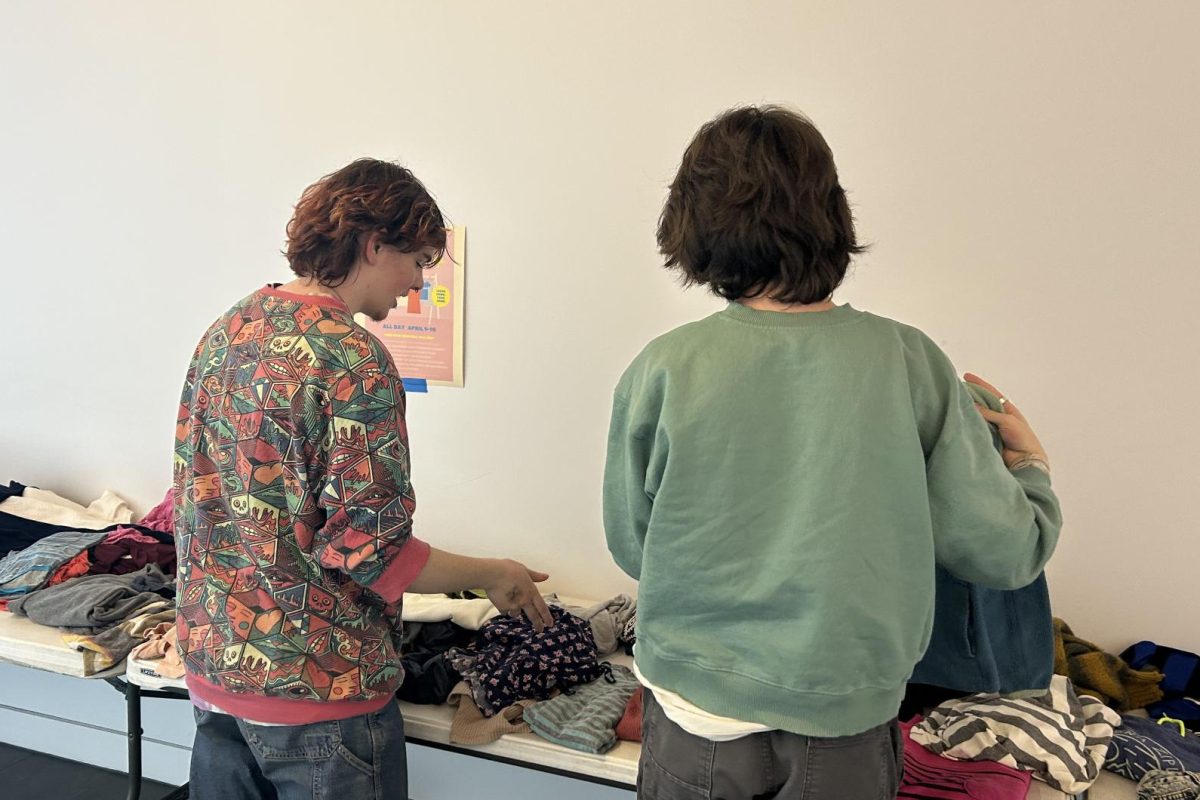 VOLUNTEER. Fashion Club members Jack Bettenburg and Rowan Moore fold clothes during their free period.