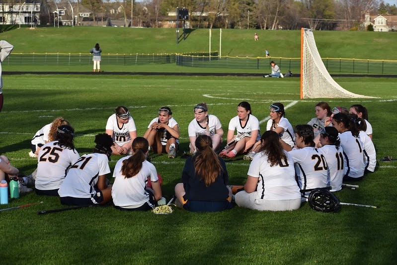 POSTGAME PEP: The team gathers to reflect on the game, come up with plays for next time, and share words of encouragement.