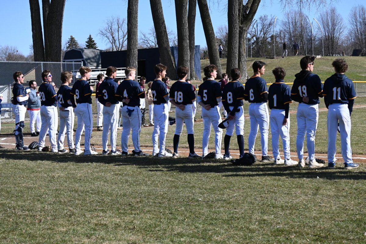 LINED UP. Both teams line up to listen to the national anthem, marking the start of the game.