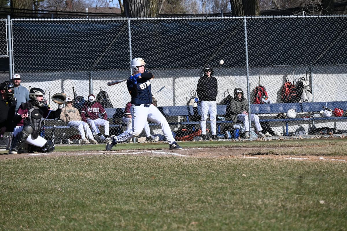 EYE ON THE BALL. Junior Peter Ostrem  takes a swing and hits a double.