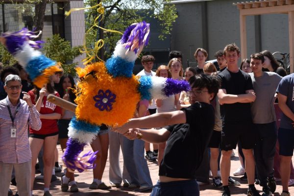 CANDY STRIKE. Junior Otto Rudolf hits off a leg of the pinata in one swing.