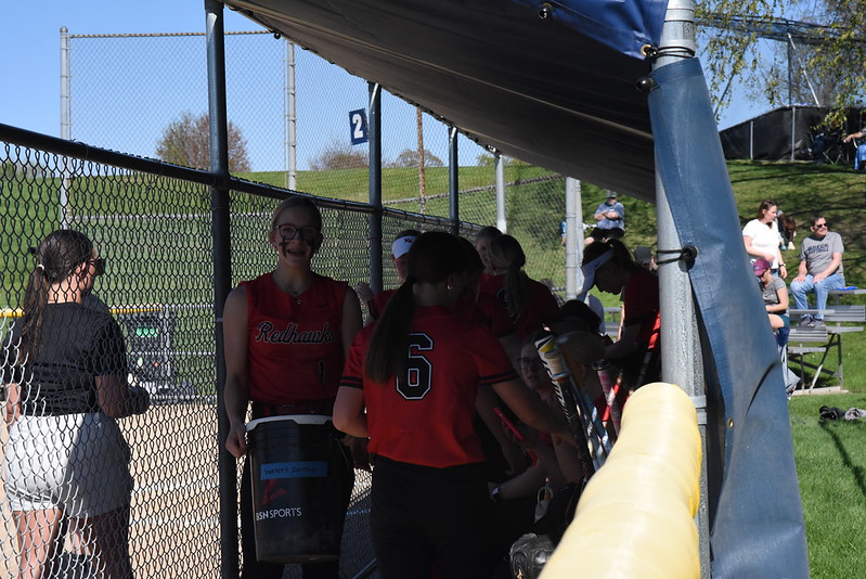TEAM BONDING: The girls gathered in the dugout, chatting in between games. Refilling the water cooler and exchanging snacks, the Redhawks refreshed themselves for game two. 