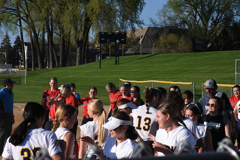 GOOD GAME: The Redhawks and the Mustangs exchange handshakes at the end of the double-header. As the sun began to set, the Redhawks’ final game against Breck for the season had officially come to a close. 
