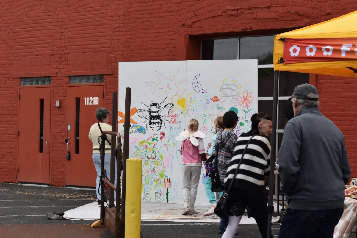 PUBLIC MURAL. One of Art-A-Whirl's traditions is the public mural where visitors are open to tables full of art supplies and a blank canvas giving light to a creative community mural. The mural is saved and placed on stage for display after every day.  