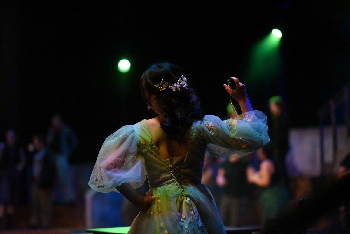 GREAT IN GREEN. Persephone (Ellie Putaski) is enveloped in green lighting and attire, contributing to the underlying theme of the Earth during the spring. 
