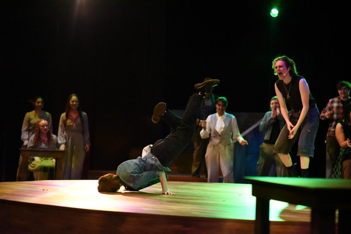 FREEZE. El Nelson does a breakdancing freeze while junior Rowan Moore cheers them on from behind. 