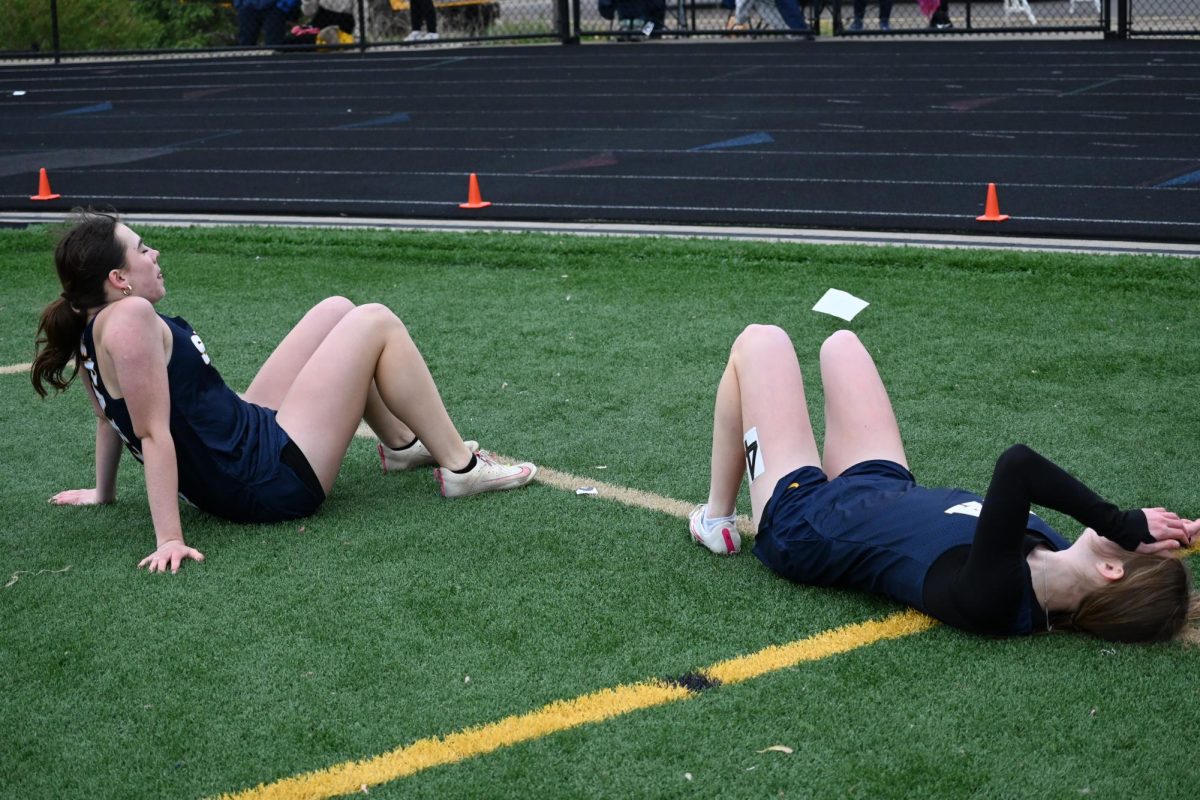 EXHAUSTED. Tuttle and Bradley lie on the turf after their 200 meter race. Both had already competed in multiple events prior.