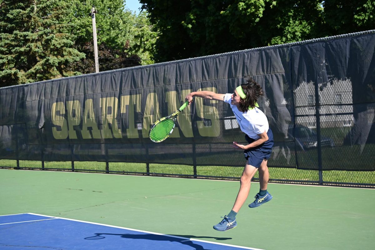 SENIOR JACOB COLTON LAUNCHES INTO A SERVE DURING DOUBLES PLAY. Colton, partnering with Ben Macedo , brought focus and finesse to the court as they captured the Section 4A doubles title.