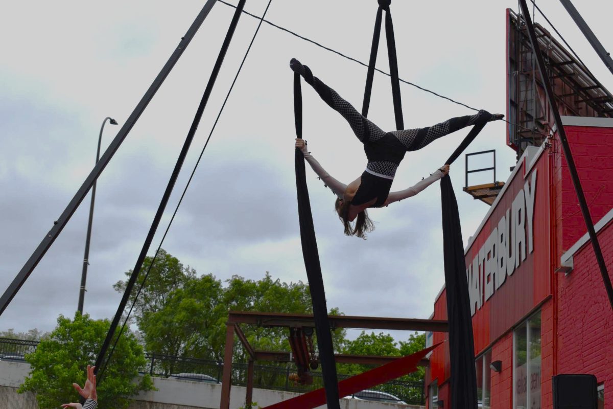 GRAVITY DEFIED. An aerial acrobat captivates the crowd mid-split high above the ground.