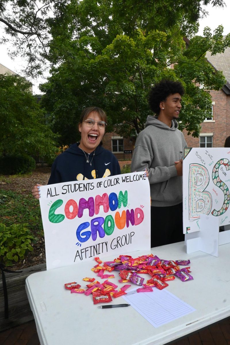 SIGN UP HERE. Junior Stella Hunter, leader of Common Ground, displays her poster to grab attention.