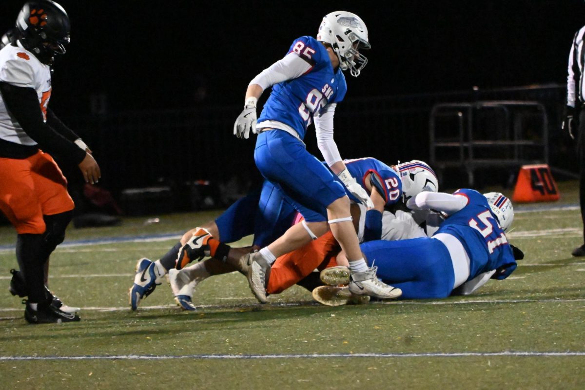 GET HIM DOWN. Seniors Bennett Sauer (#20) and Cutler Crook (#57) tackle a Minneapolis South running back.