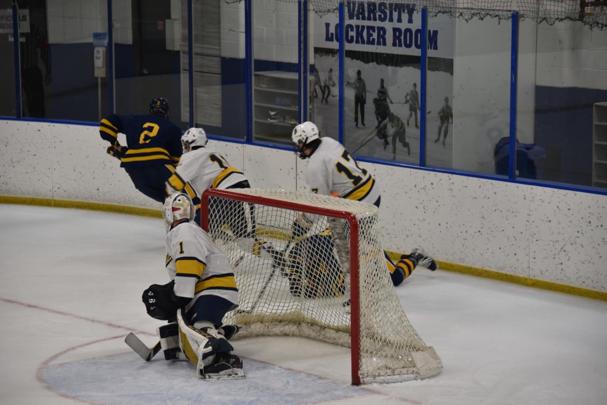 CHALLENGE. The Spartans challenge the other team by working to get the puck out of the zone. 