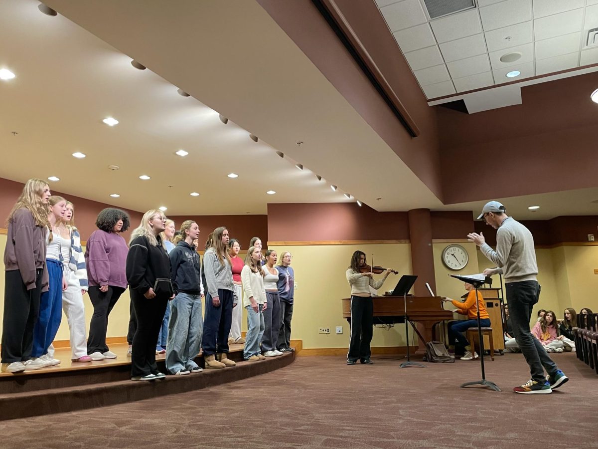 SINGING COUNTRY. Summit Singers sings the 2024 western song Inconsolable by Katie Gavin. Junior Naomi Glozman joins the choir on the violin. This slower hopeful song brought residents to close their eyes and sway to the music. This song will be performed at the Pops Concert. Unfortunately
 Summit Singers didn't have their full crew, typically there's a few more of them. Due to them not having choir during this class period some were able to join while others remined in their normal class. I thought it went really well! "For me, one of the highlights of the trip was watching our Summit Singers give a fantastic performance with only about 1/3 of their normal group, and they sounded incredible. Because this is the third year in a row that we've performed there, we have singers who performed there as Middle Schoolers, and a number of folks in the audience have been seeing these kids for three years as well. I loved seeing our students shake hands with residents and say thank you. A former SPA teacher, Kate Mura, lives at Carondelet, and before the concert she was chatting with a big group of seniors, which was a really neat connection to make," said Kraack.