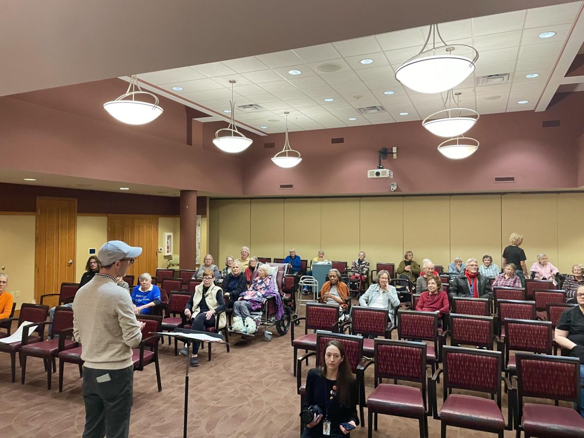 MORE VISITORS. Mr. Kraack gave introductions to each song, each choir, and each person who had helped play an instrument. With more than 30 residents trickling in to hear the choirs, the performance offered a welcome and uplifting break in their day. As residents came and went, the melodies seemed to draw smiles from everyone who passed through. Some stayed for a song, others for the whole performance, but all left with a little more joy.