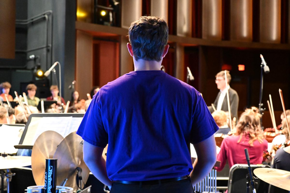 PERCUSSIONS LEADER. Senior James Welsh leads a team of three in the percussions section. He stands still and counts until his turn to play.