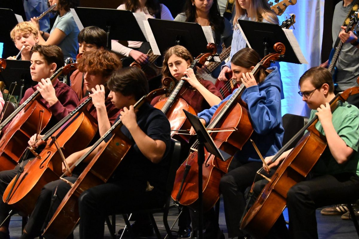 CELLOS AT REST. Academy Symphony cellists wait for their turn to play again during a medley of songs from Wicked.