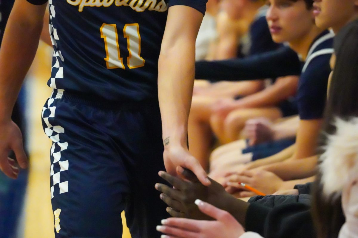 SUPPORT. As players came off the court, they walked past their teammates on the bench, exchanging high fives and offering encouragement to one another.