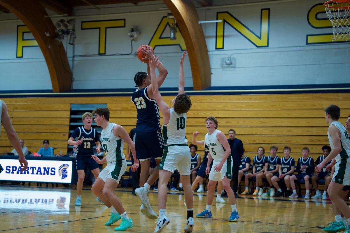 JUMP SHOT. Senior Ezra Cunningham takes a shot during the game against the Mounds View Mustangs.