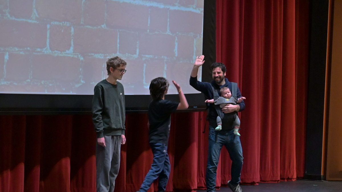 HOPEFUL HIGH-FIVE. Science teacher Joseph Martin high-fives ninth-grader Peter Gillen-O’Neel after receiving a strong score. Gillen-O’Neel became the first graph-matching victor from Martin’s class. “It was fun to be up there and get the support from the students,” Martin said.