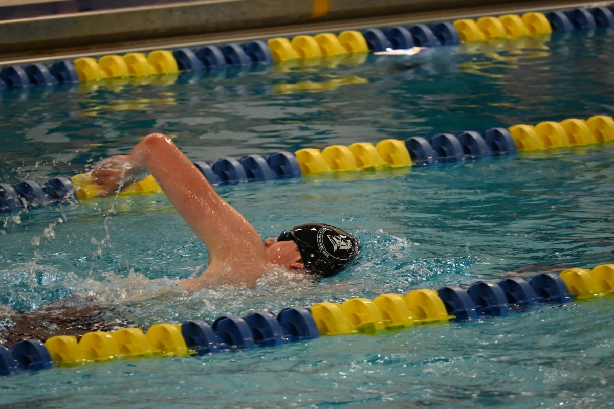 SWIMMER STROKE. Sophomore Alex Haupt reaches out of the water to complete another stroke in the 100 freestyle. After a close race, Haupt placed second.